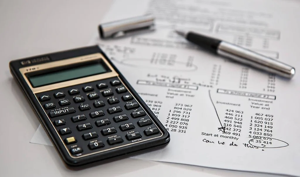 Calculator and pen on tax sheet comparing diesel and gasoline costs.