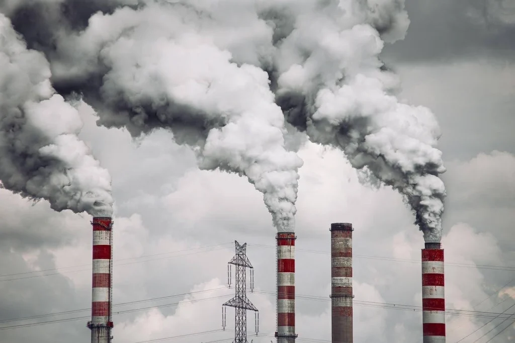 Factory chimneys releasing thick smoke, showing diesel’s higher pollution impact.