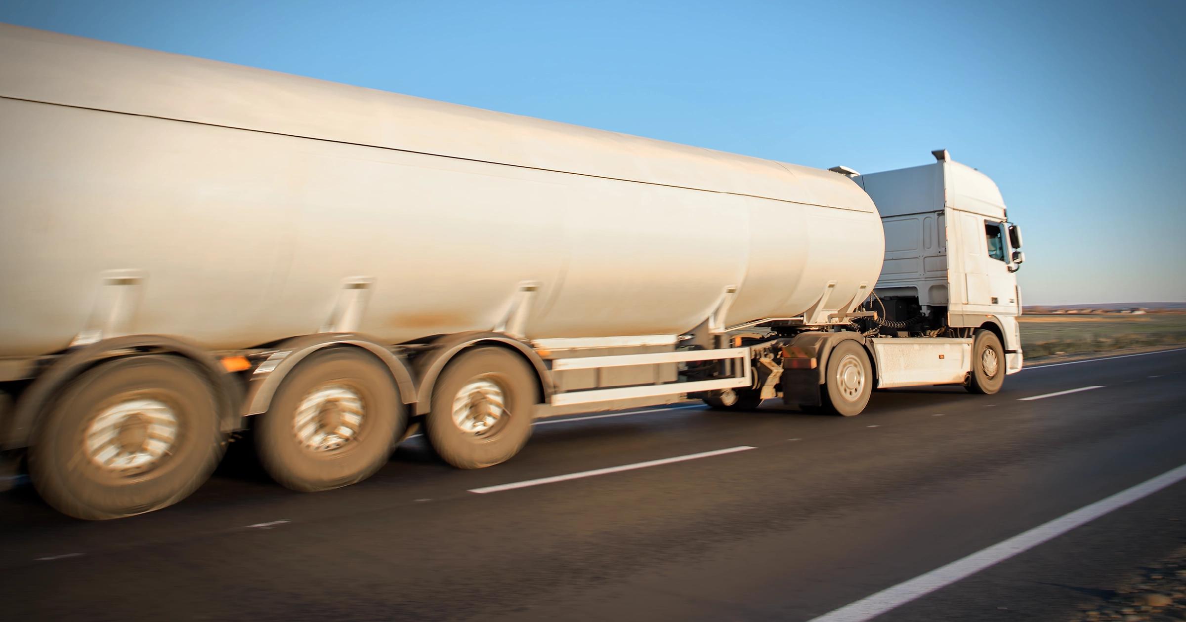 Wholesale fuel tanker truck driving on the highway delivering fuel