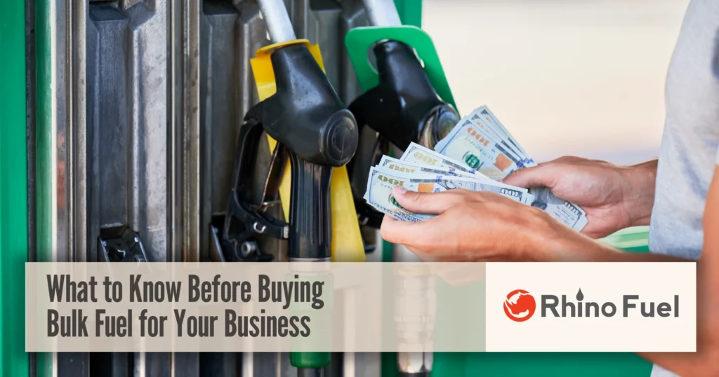 Person holding cash at a fuel pump illustrating bulk fuel purchasing considerations and costs for businesses.
