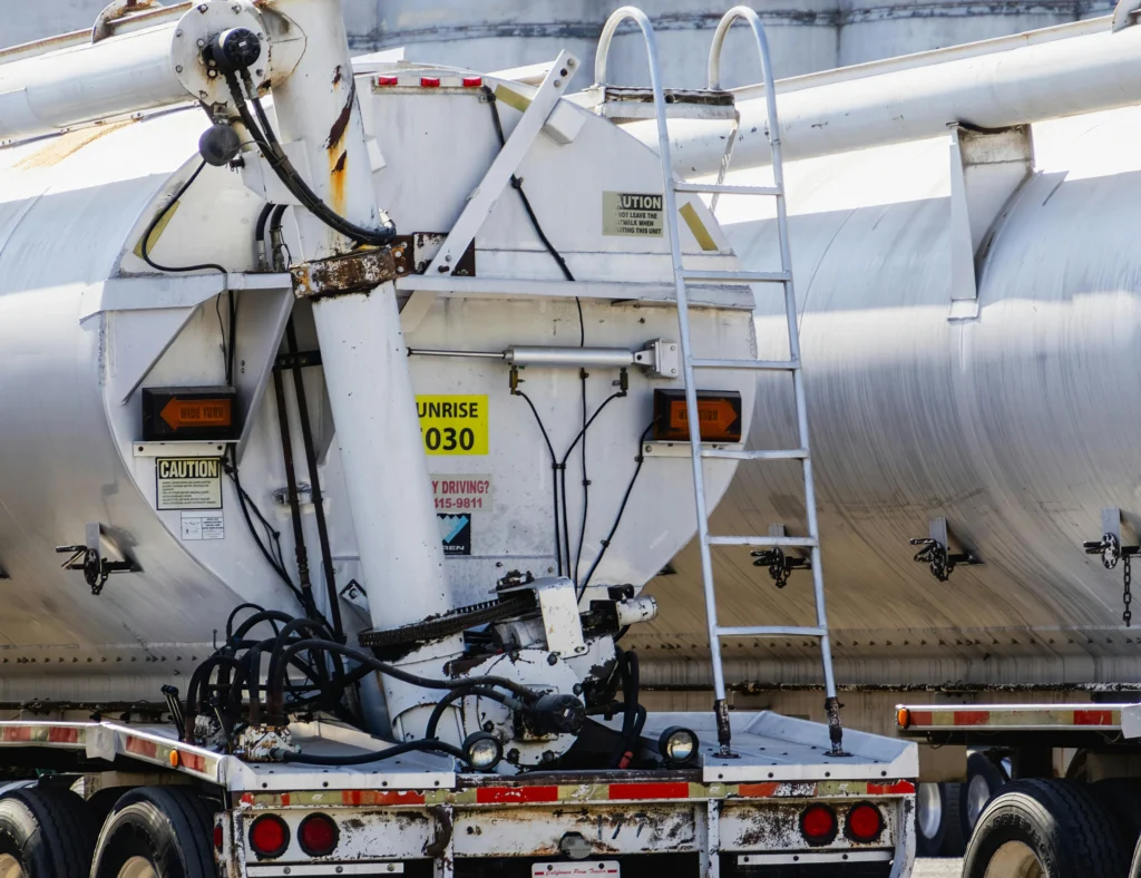 Close-up of tanker truck connected to fuel storage containers