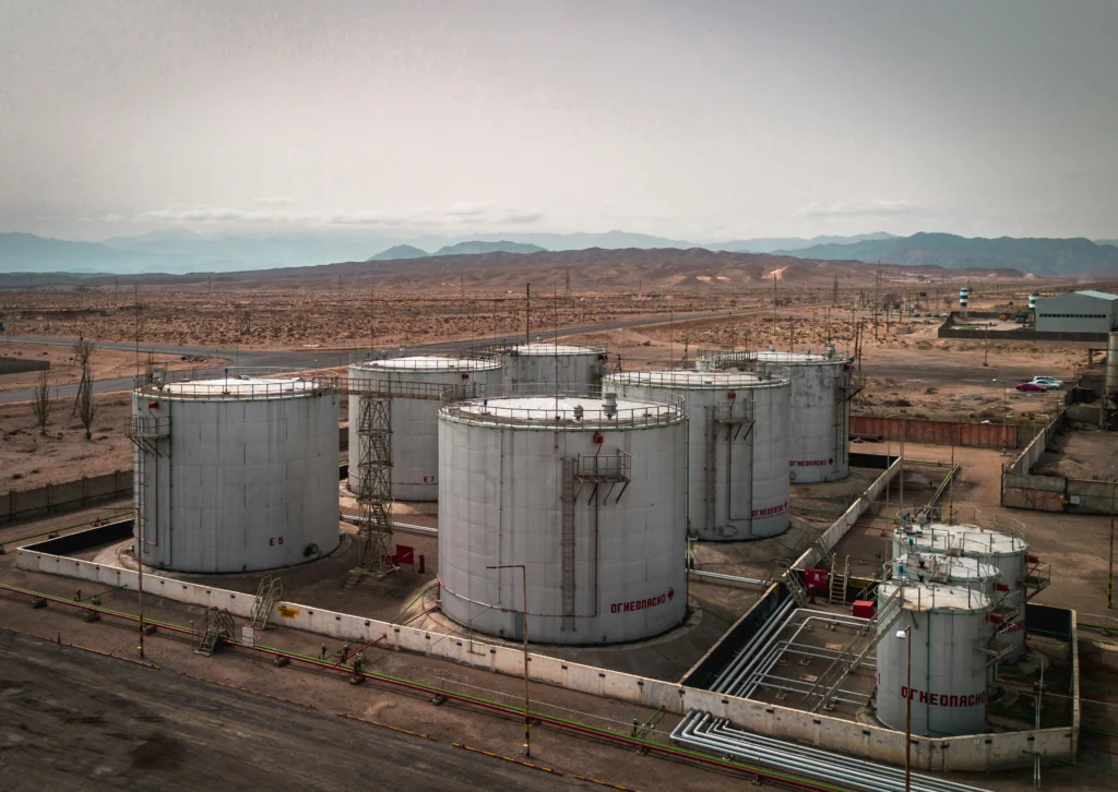 Industrial storage tanks in a desert facility highlighting contamination risks that lead to common contaminated fuel symptoms such as clogged injectors and rough idling.