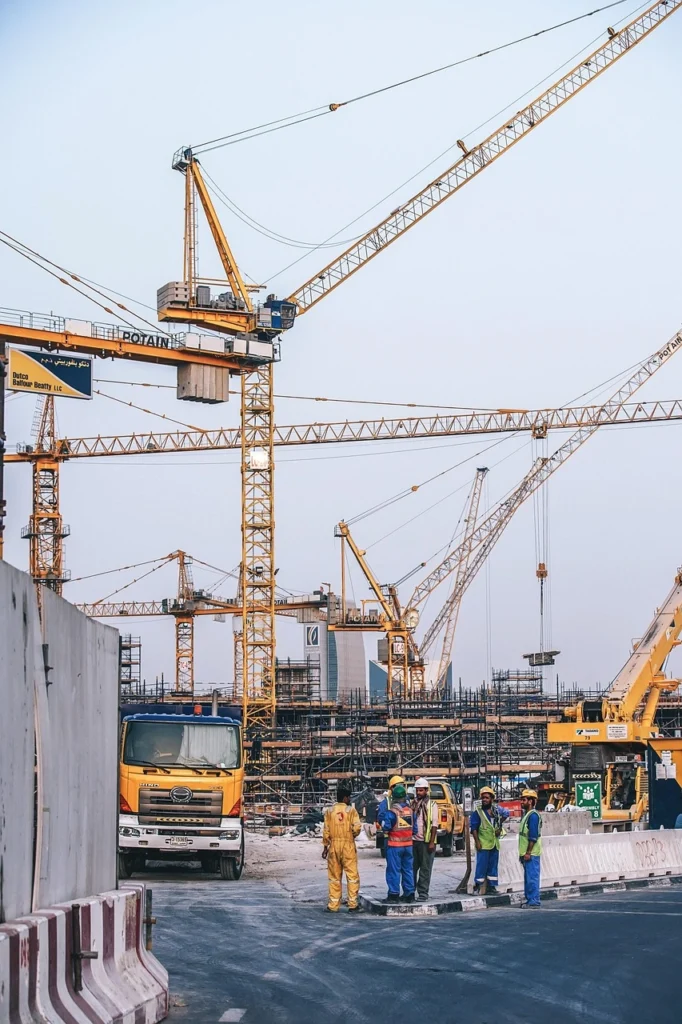 Fuel downtime cost affecting construction site operations with cranes, workers, and equipment delays on active project site